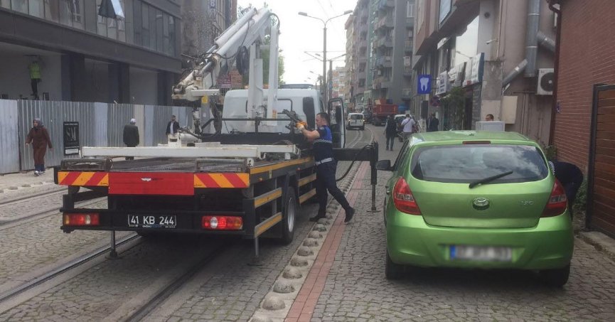 Tramvay yoluna park  edilen araçlar çekiliyor